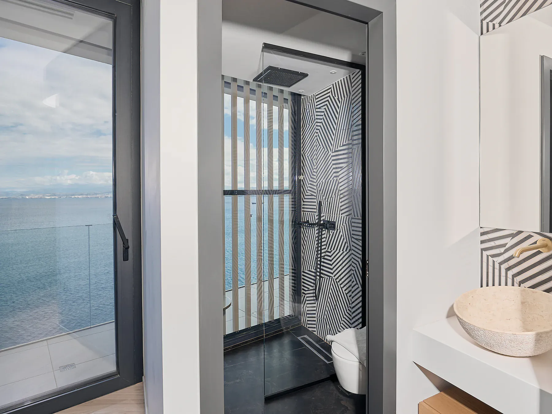 Stylish bathroom with walk-in shower and panoramic sea view.