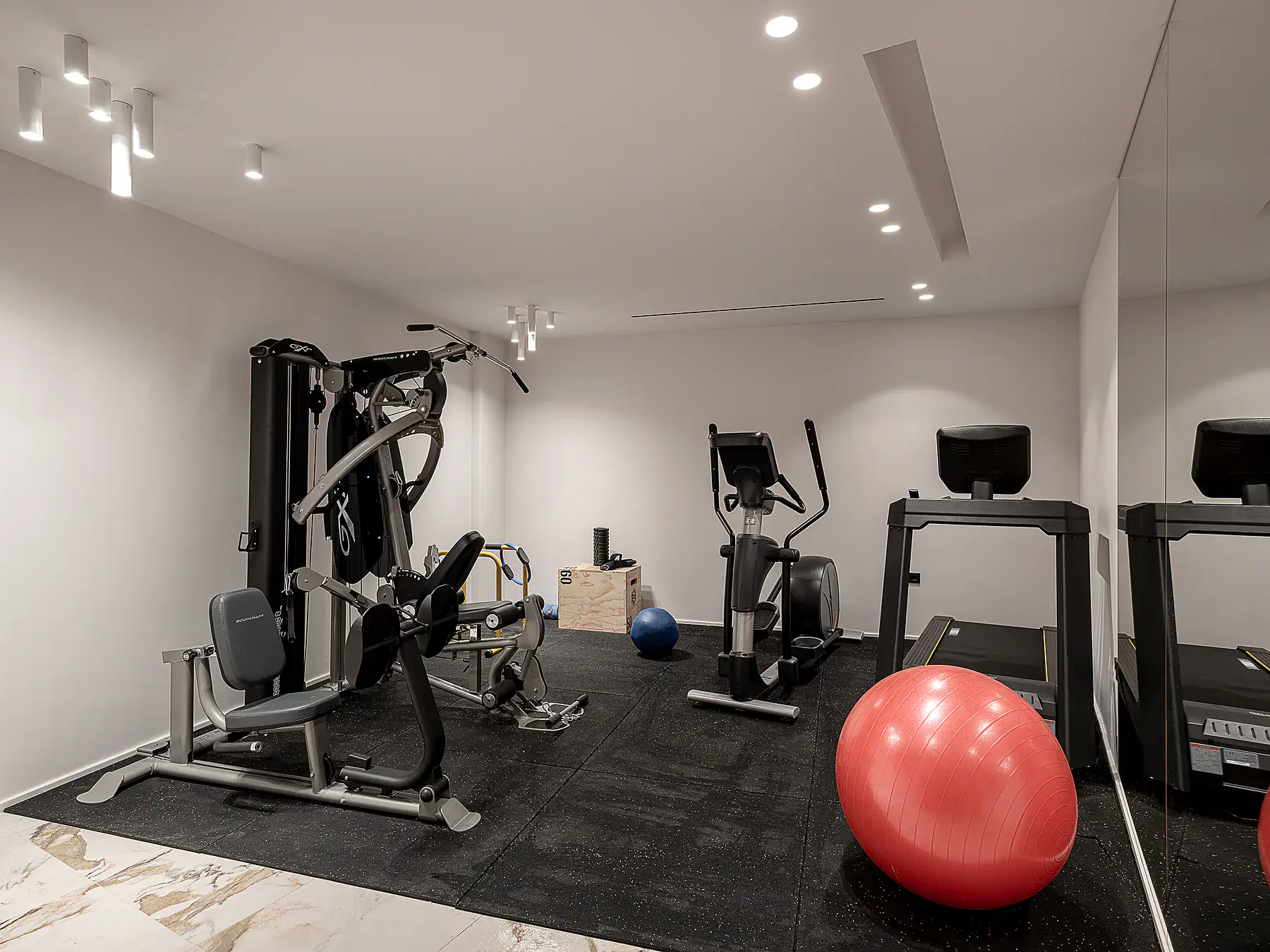 Private villa gym with professional equipment and minimalist design.