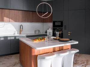 Contemporary kitchen with central island, minimalist lighting, and natural wood finishes.