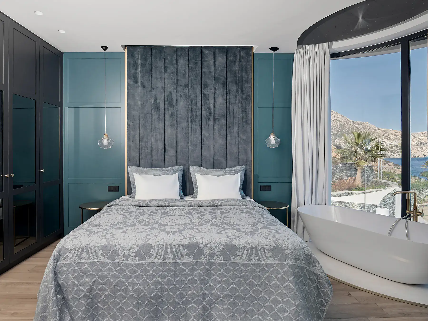 Luxurious bedroom with large windows, soft textiles, and sea horizon views.